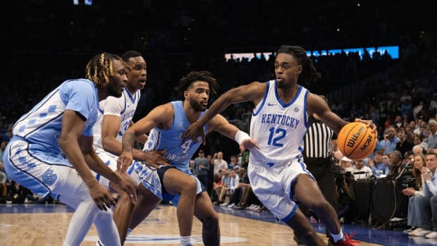Dec 16, 2023; Atlanta, Georgia, USA; Kentucky Wildcats guard Antonio Reeves (12) dribbles the ball against North Carolina Tar Heels guard RJ Davis (4) and forward Jae'Lyn Withers (24) during the first half at State Farm Arena. Mandatory Credit: Jordan Godfree-USA TODAY Sports